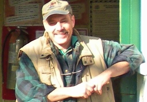 A Man Wearing a Cap and Jacket is Smiling